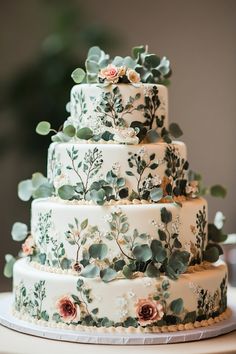 a wedding cake decorated with flowers and greenery