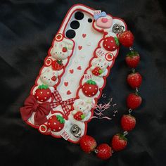 a cell phone case is decorated with strawberries and teddy bears, as well as a beaded necklace