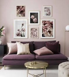 a living room filled with purple couches and pictures on the wall above it's coffee table