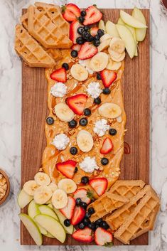 waffles and fruit on a wooden cutting board