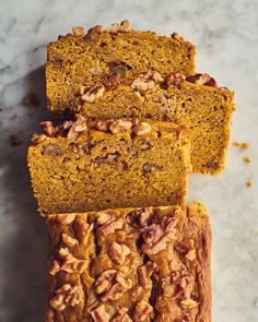 three slices of pumpkin bread with nuts on top and one slice cut off from it