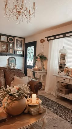 a living room filled with furniture and a chandelier hanging above the couches