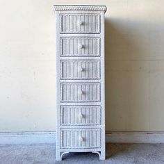 a white wicker chest with five drawers