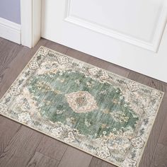 a green and beige area rug on the floor next to an open door with white trim