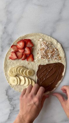 someone is decorating a cake with chocolate and strawberries on it for the dessert