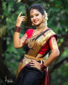 a woman in a sari posing for the camera with her hand on her hip