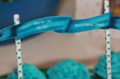 cupcakes with blue frosting and ribbons on them