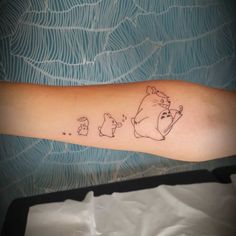 a person with a tattoo on their arm that has winnie the pooh and pig