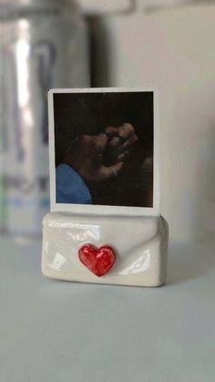 a small photo frame with a red heart on it