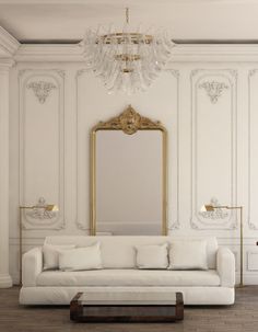 a living room with white couches and a gold framed mirror