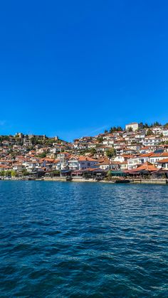 houses on the hill above the water with blue sky in the backgrouds