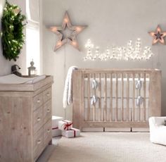 a baby's room decorated for christmas with stars on the wall and lights in the crib