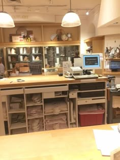 the inside of a store with lots of items on display and people working in the background