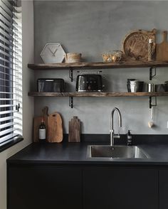 a kitchen with open shelving above the sink