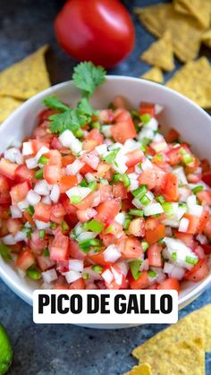 a white bowl filled with salsa next to some tortilla chips and a lime