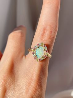 One of a kind 14k Yellow Gold Australian Opal Ring, enraptured by a dreamy pastel halo of Aquamarine, Pink Sapphires and Yellow Sapphires. 💌 Please write desired size (between 4-8) in *Notes* section at checkout Opal enhances cosmic consciousness and imparts mystical visions. Acting as a mirror, it reflects your thoughts and feelings back to you while shielding you as a karmic protector to deflect empathic emotions that are shone onto you by others. Opal is a teacher - amplifying our emotions s Multicolor Oval Jewelry With Halo Setting, Multicolor Oval Halo Setting Jewelry, Oval Multicolor Jewelry With Halo Setting, Fine Jewelry Multicolor Halo Setting, Multicolor Halo Rings Fine Jewelry, Multicolor Halo Jewelry For Wedding, Multicolor Jewelry As A Gift, Fine Jewelry With Multicolor Halo, Multicolor Halo Rings As A Gift