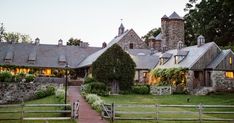 an old stone house with ivy growing on it's walls and windows at dusk