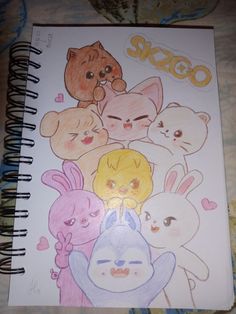 an open notebook with drawings of various cartoon characters on the cover and in front of it