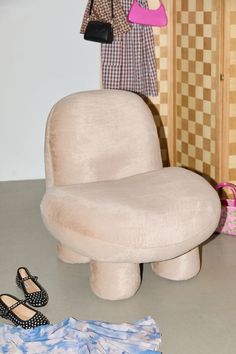 a woman's purse and shoes are on the floor next to a fake chair