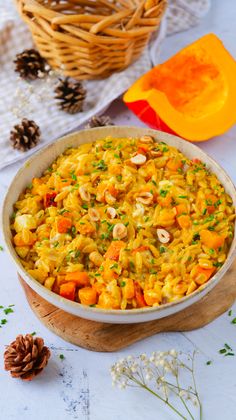 a casserole dish with carrots and nuts in it on a white table