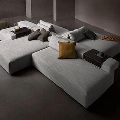 a large white couch sitting on top of a gray floor