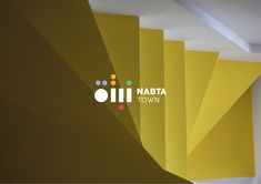 the logo for matta town is shown in front of yellow and white walls with different colors