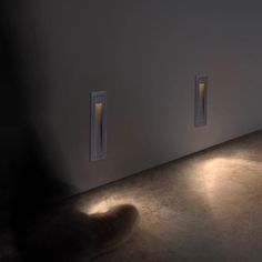 two lights that are on the side of a wall next to each other in a room