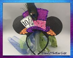 a mickey mouse ears headband with a name tag on it and purple sequins