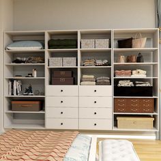 an organized bedroom with white shelving and drawers