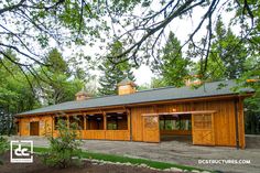 an image of a horse barn with lots of wood on the sides and doors open