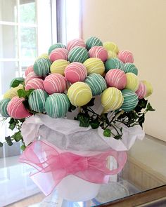 a vase filled with lots of candy covered in pink and green frosted chocolates