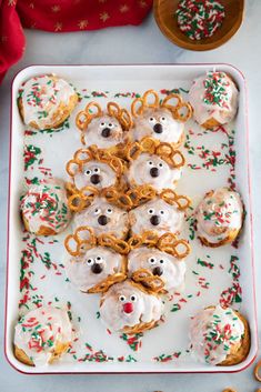 a platter filled with donuts covered in white frosting and pretzels