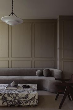 a living room filled with furniture next to a wooden table and wall mounted light fixture