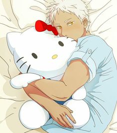 a person laying in bed with a hello kitty stuffed animal on their chest and head