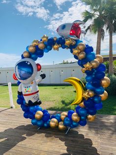 an astronaut balloon arch with gold and blue balloons