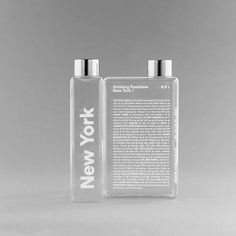 two clear bottles sitting next to each other on a gray background with the words paris printed on them