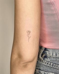 a woman's arm with a single rose tattoo on it