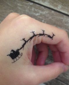 a person's hand with a small tattoo on their left wrist, holding onto a string