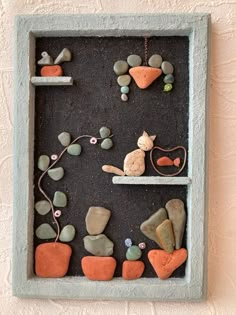 there is a shadow box with rocks and stones in the shape of animals on it