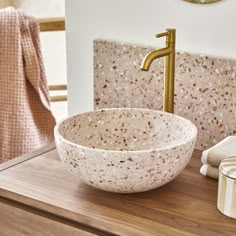 a bowl shaped sink sitting on top of a wooden counter