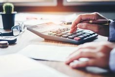 a person is using a calculator at a desk