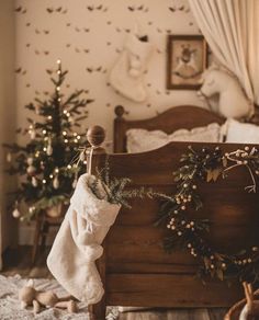 a bedroom decorated for christmas with stockings on the bed and trees in the room behind it