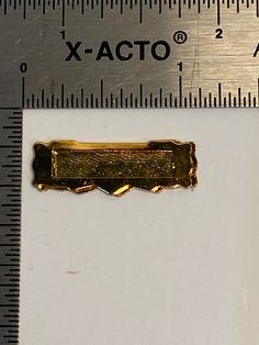 a piece of metal that has been placed on a ruler with the word x - acto in it