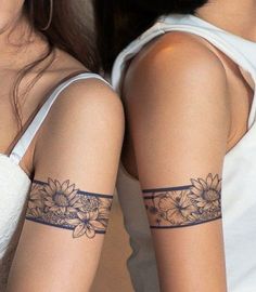 two women with tattoos on their arms and armbands, both showing sunflowers