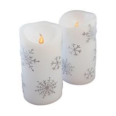 two white candles with snowflakes on them