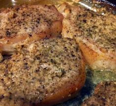 three pieces of meat sitting on top of a pan covered in sauce and seasoning