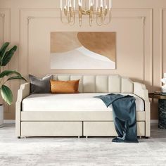 a living room scene with focus on the daybed and pillows, as well as an art piece