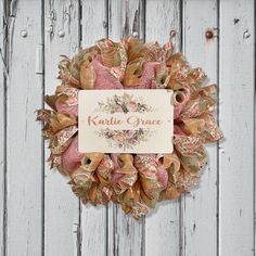 a wreath on the side of a wooden fence with a name tag attached to it