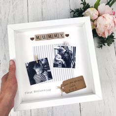 a person holding up a white frame with photos on it and a wooden name tag