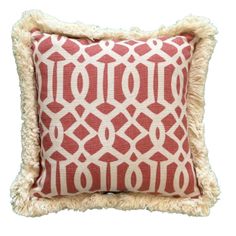 a red and white pillow with fringes on the bottom, in front of a white background